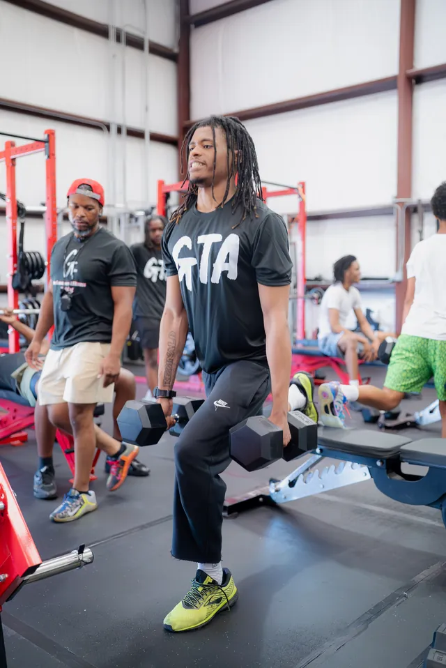Athlete smiling through a heavy dumbbell exercise