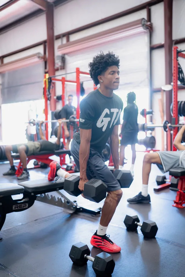 Athlete doing a dumbbell lunge in the strength area