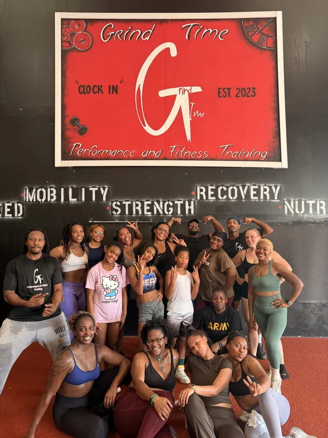 Grind Camp Saturday crew posing together under the Grind Time sign