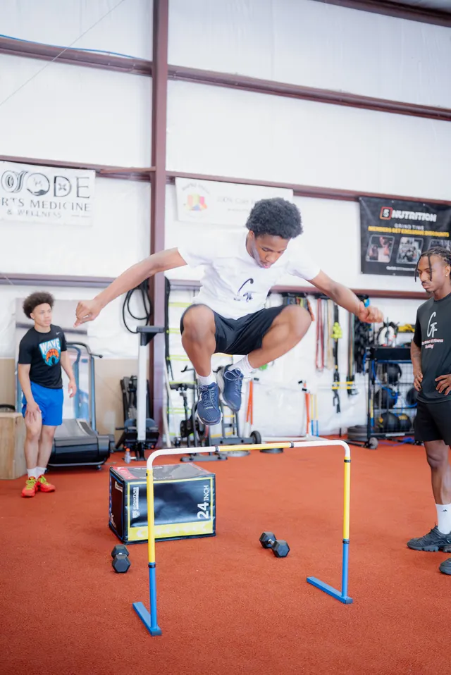 Athlete jumping a hurdle with arms out for balance