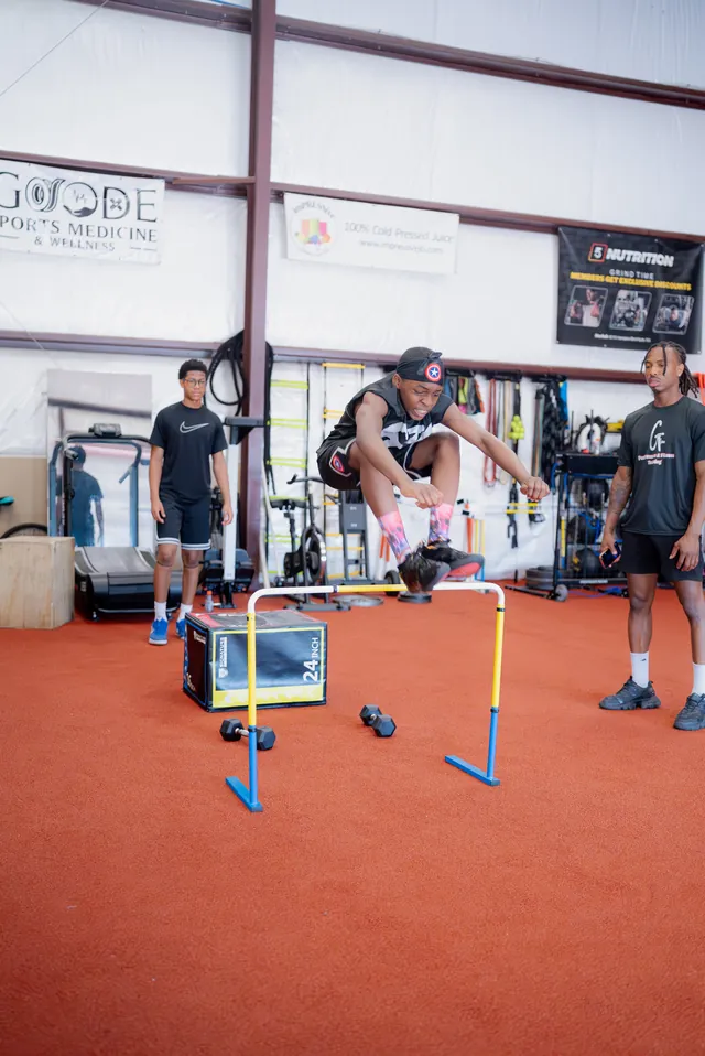 Athlete tucking over a hurdle in the Grind Time facility
