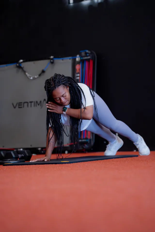 Woman holding a deep lunge stretch on a mat during warm-up